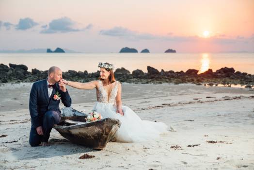 A couple enjoys a romantic moment on the beach at sunset in koh samui, surrounded by nature and love.