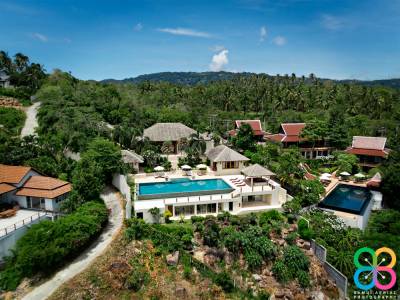 Luxurious villa surrounded by lush greenery, featuring a pool and modern architecture in a tropical setting.